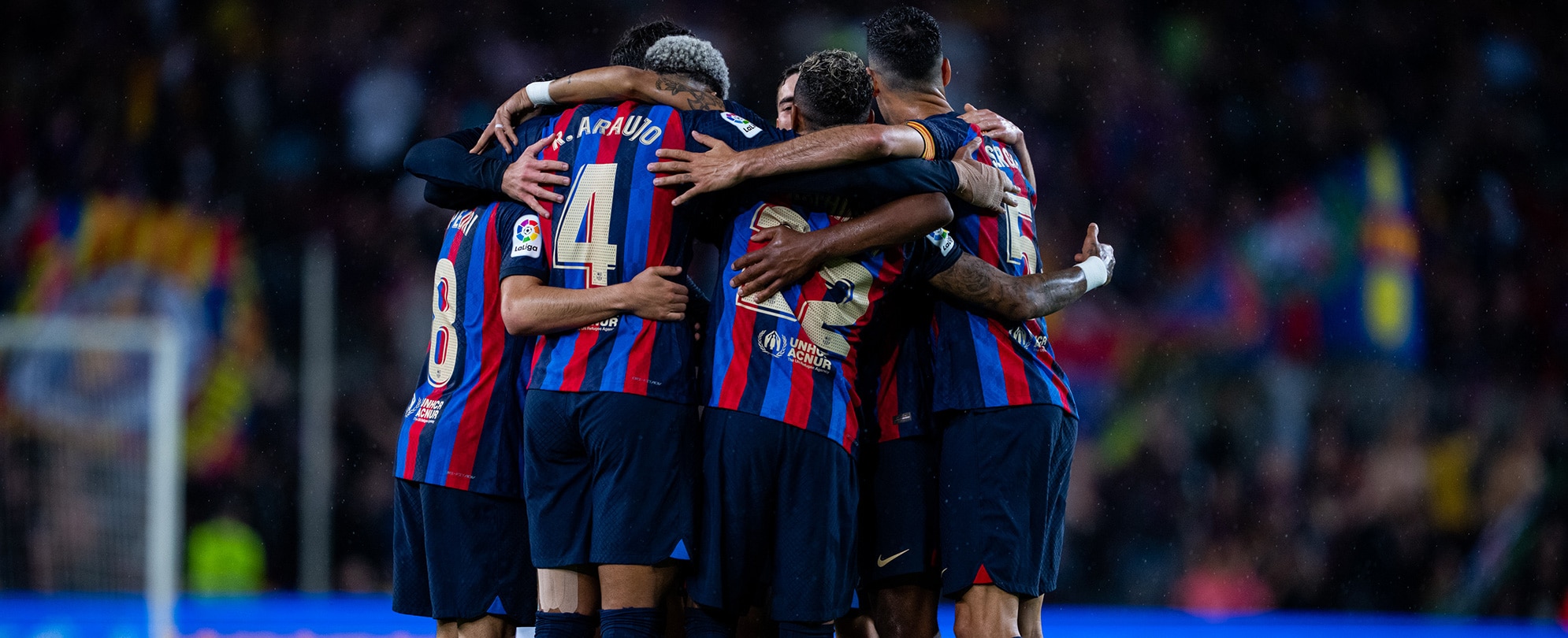 A group of Barcelona soccer players in a huddle.